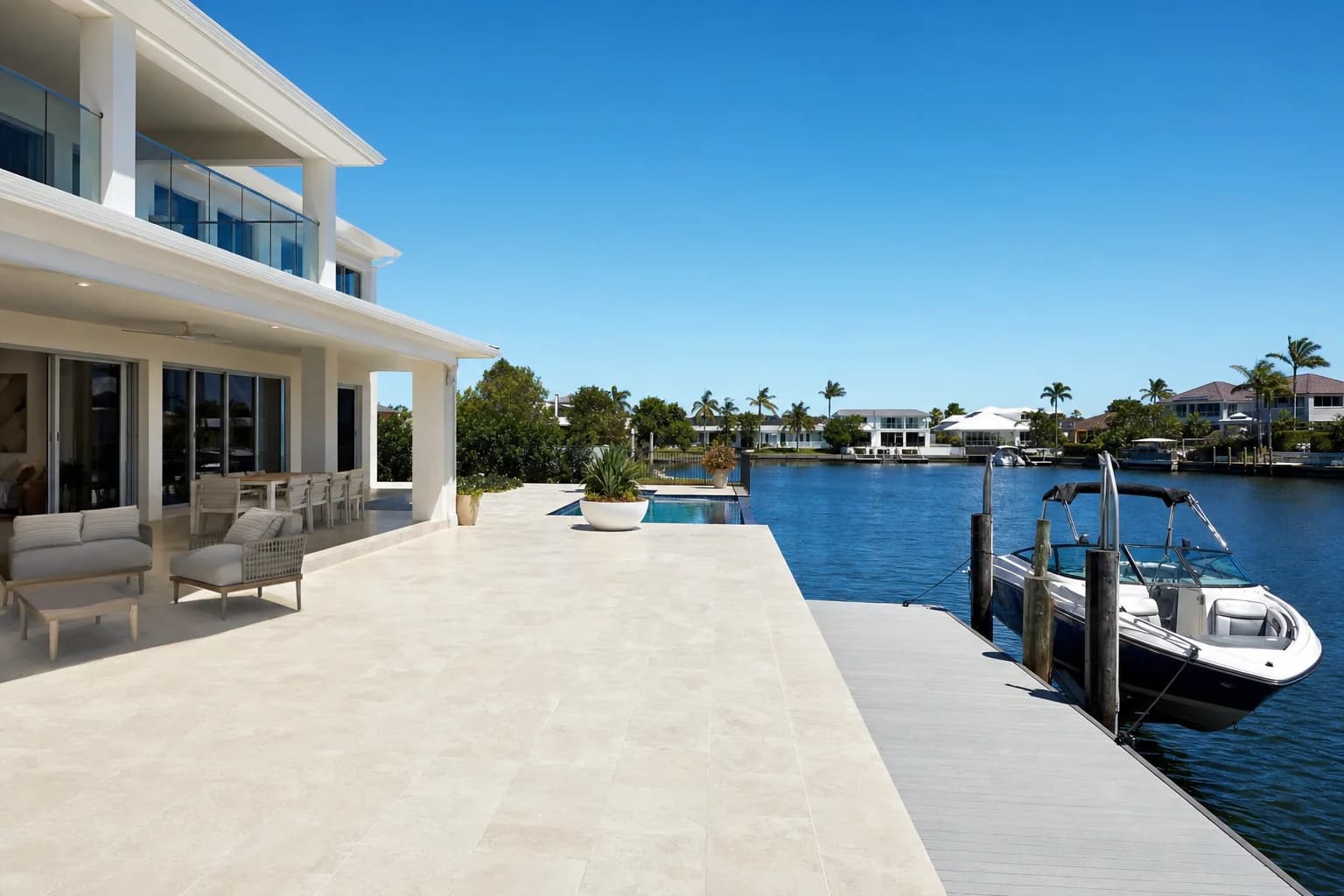 Pale porcelain paving across a canal-side alfresco area in Mandurah running out to the edge of a private jetty